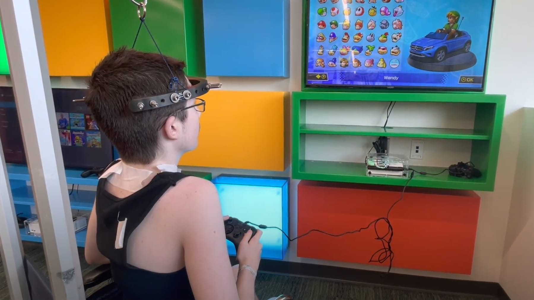 A child in a hospital gaming room choosing a character in a racing game